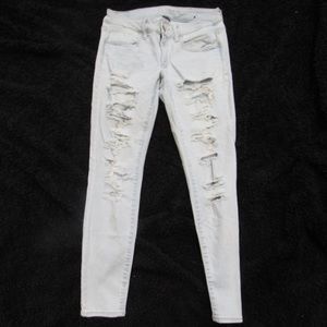 Light wash heavily ripped jeans.